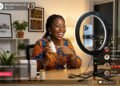 Young Ivorian entrepreneur doing a TikTok live shopping session on smartphone