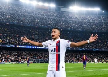 Kylian Mbappé in PSG white away jersey celebrating a hat-trick goal at Camp Nou stadi